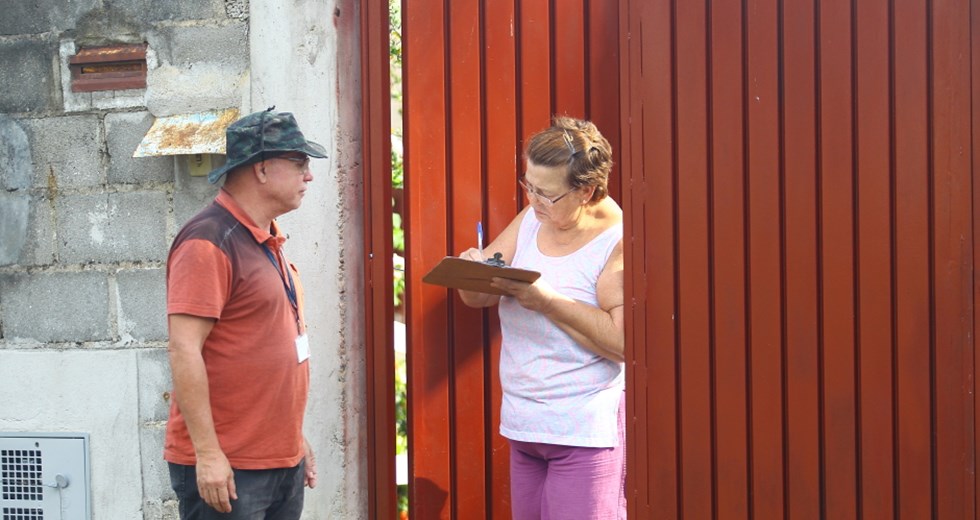 A moradora Marta Dias recebe servidor da Prefeitura