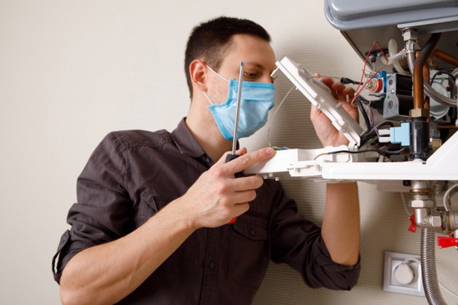 um-homem-consertando-uma-caldeira-com-uma-mascara-medica_93200-3347.jpg