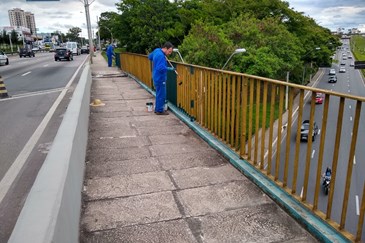 Equipes da Prefeitura durante a pintura do gradil do viaduto Kanebo, na zona sul; também estão sendo pintados os muros do Anel Viário