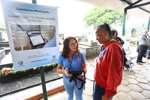 Cláudia recebendo o auxilio da Urbam na busca do jazigo do pai.